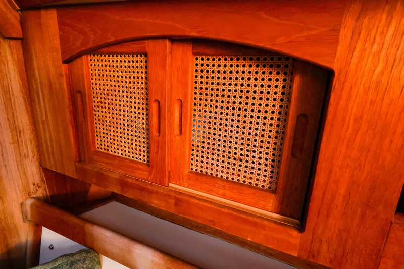 Slide: The Image of Wooden cabinet with woven rattan doors inside a 1990 Ericson 32.5 sailboat. - 34