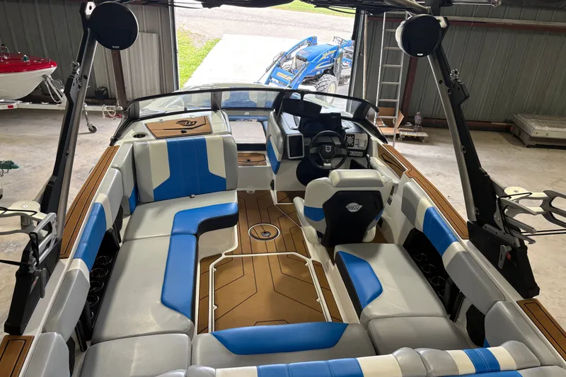 Slide: The Image of 2023 Malibu Wakesetter 21 LX interior with blue and white seating in a garage. - 8