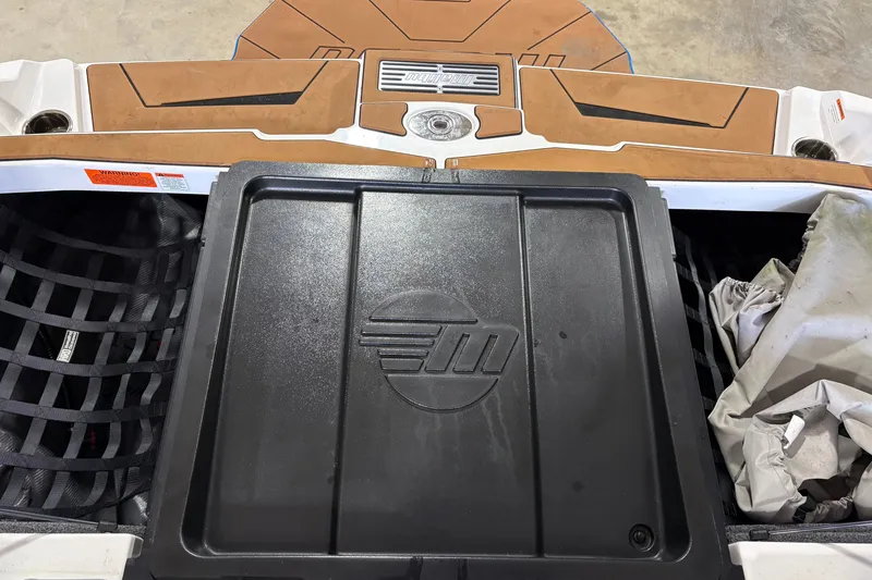 Slide: The Image of 2023 Malibu Wakesetter 21 LX rear storage compartment with logo and accessories. - 4