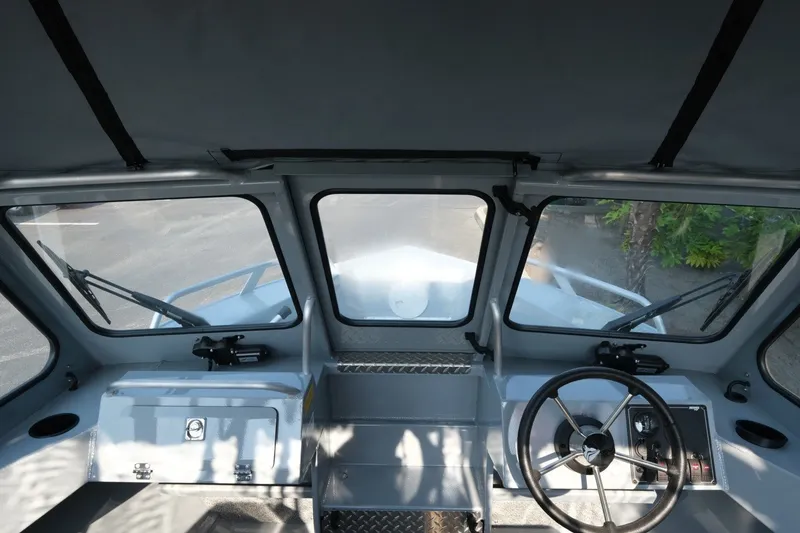 Slide: The Image of Interior view of 2026 Hewescraft 180 Sportsman boat cockpit with steering wheel and dashboard. - 14