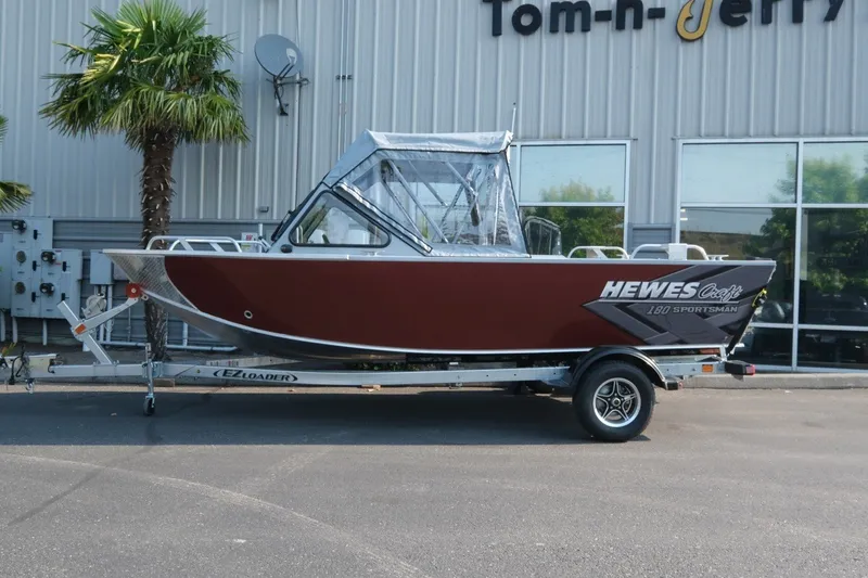 Slide: The Image of 2026 Hewescraft 180 Sportsman boat on trailer, parked outside dealership. - 3