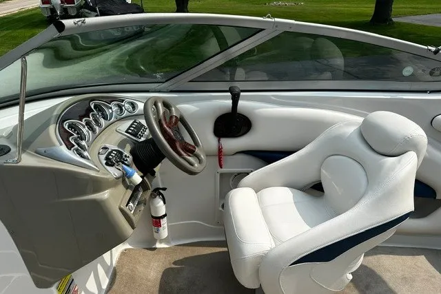 Slide: The Image of 2007 Crownline 260 LS boat interior with steering wheel, dashboard, and white captain's chair. - 17