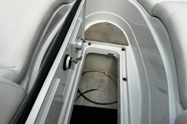 Slide: The Image of 2007 Crownline 260 LS boat interior storage compartment with white seating and open hatch. - 22