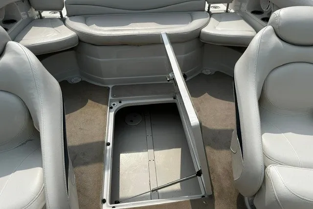 Slide: The Image of 2007 Crownline 260 LS boat interior with open storage compartment, featuring gray seating. - 18