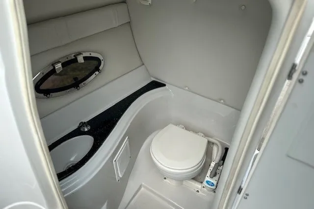 Slide: The Image of 2007 Crownline 260 LS boat bathroom with sink, toilet, and porthole window. - 16