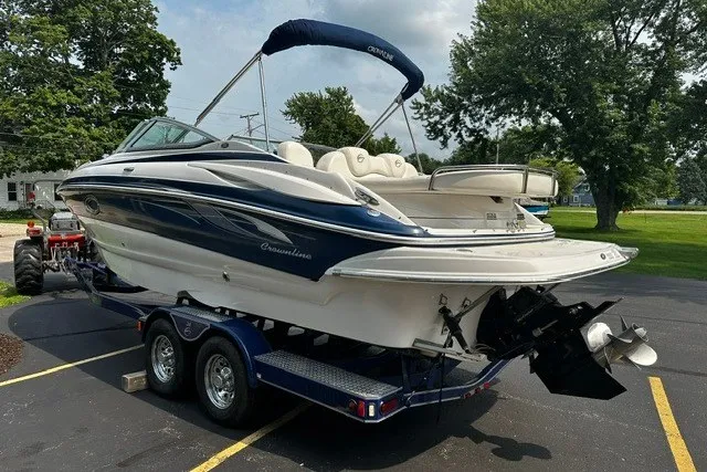 Slide: The Image of 2007 Crownline 260 LS boat on trailer, parked outdoors, featuring sleek design and blue accents. - 3