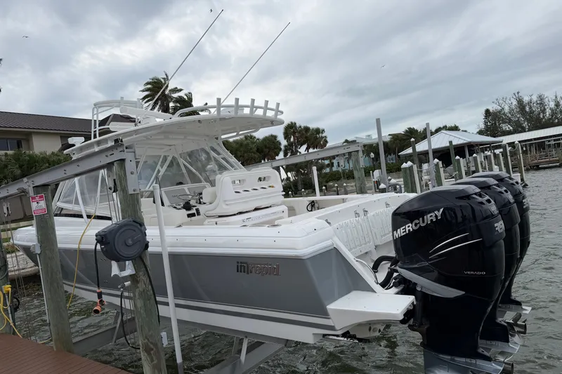 Slide: The Image of 2010 Intrepid 370 Cuddy boat with Mercury engines docked by the water. - 5