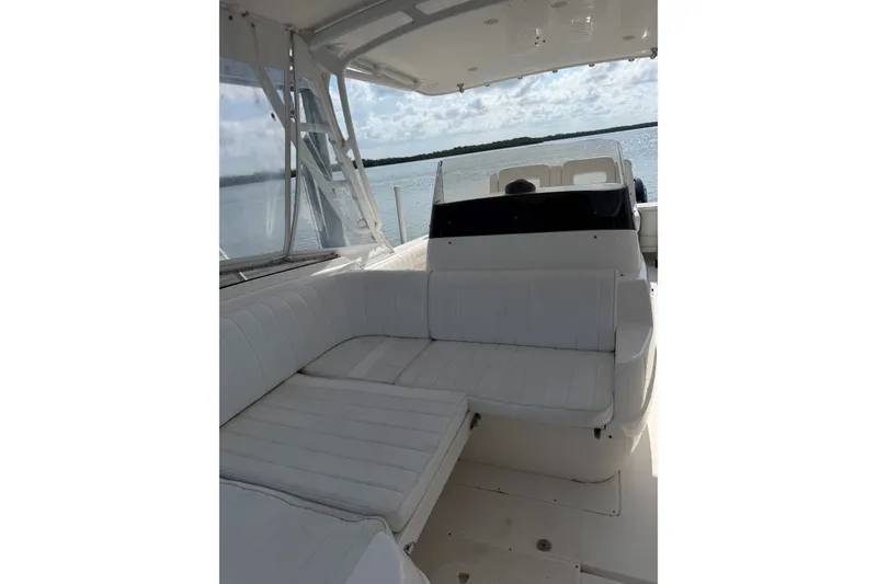 Slide: The Image of 2010 Intrepid 370 Cuddy boat interior with white seating and open water view. - 13