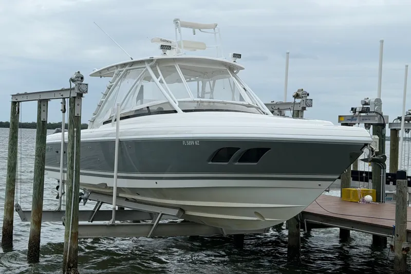 The Image of 2010 Intrepid 370 Cuddy boat on lift at dockside, overcast sky. - 2
