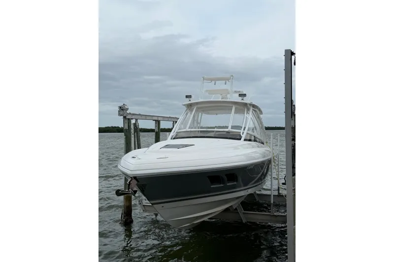 Slide: The Image of 2010 Intrepid 370 Cuddy boat docked on a lift, overcast sky in background. - 3