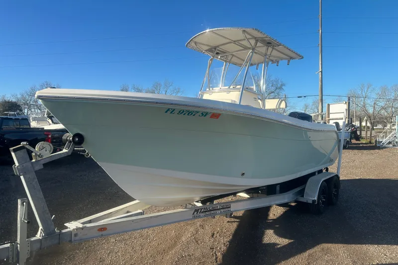 Slide: The Image of 2021 Cobia 220 Center Console boat on trailer under clear blue sky. - 6