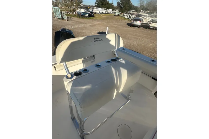 Slide: The Image of 2021 Cobia 220 Center Console boat with cushioned seating and rod holders. - 9