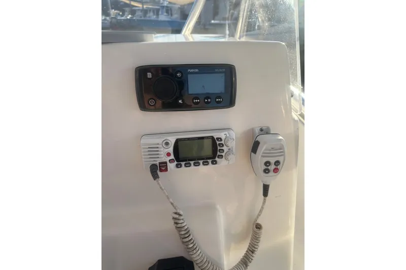 Slide: The Image of 2021 Cobia 220 Center Console boat dashboard with radio and communication devices. - 21