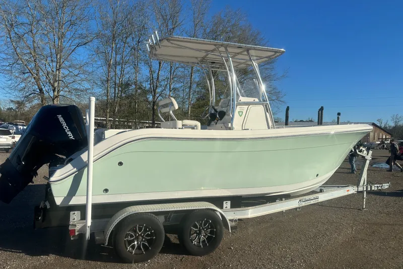 Slide: The Image of 2021 Cobia 220 Center Console boat on trailer, featuring a sleek design and Mercury engine. - 3