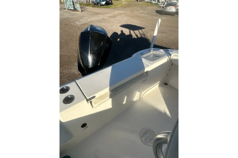 Slide: The Image of 2021 Cobia 220 Center Console boat interior with engine, parked outdoors. - 10