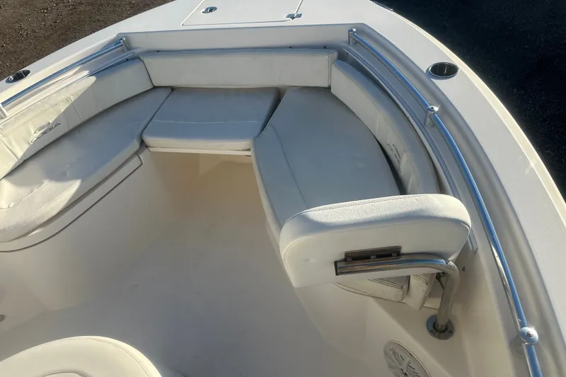 Slide: The Image of 2021 Cobia 220 Center Console boat interior with cushioned seating and stainless steel railings. - 18