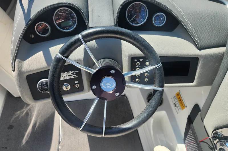 Slide: The Image of Steering wheel and dashboard of a 2012 Cobalt 220 boat, featuring gauges and controls. - 7