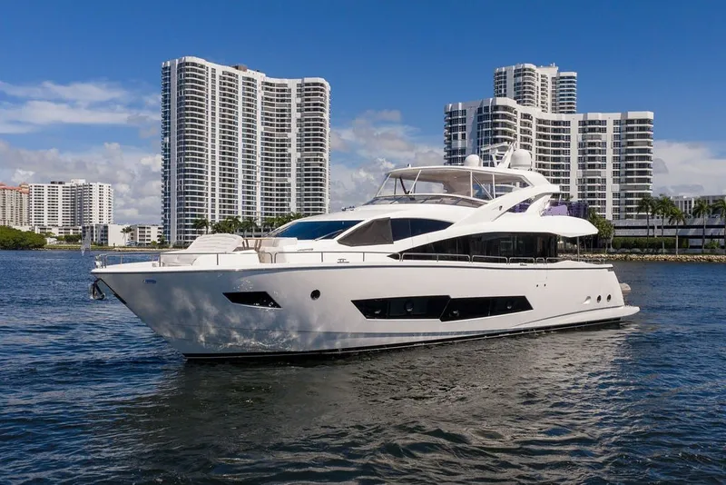 Slide: The Image of 2019 Sunseeker 86 Yacht cruising near modern high-rise buildings on a sunny day. - 12