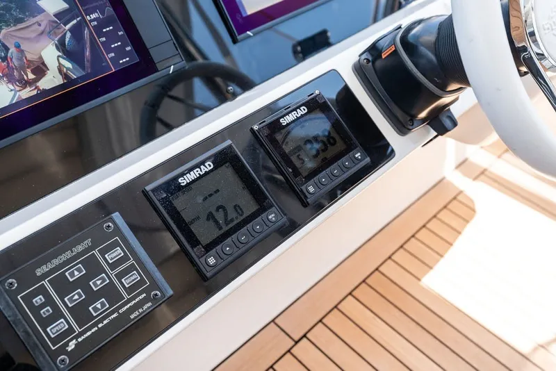 Slide: The Image of Control panel of a 2019 Sunseeker 86 Yacht with Simrad displays and steering wheel. - 54