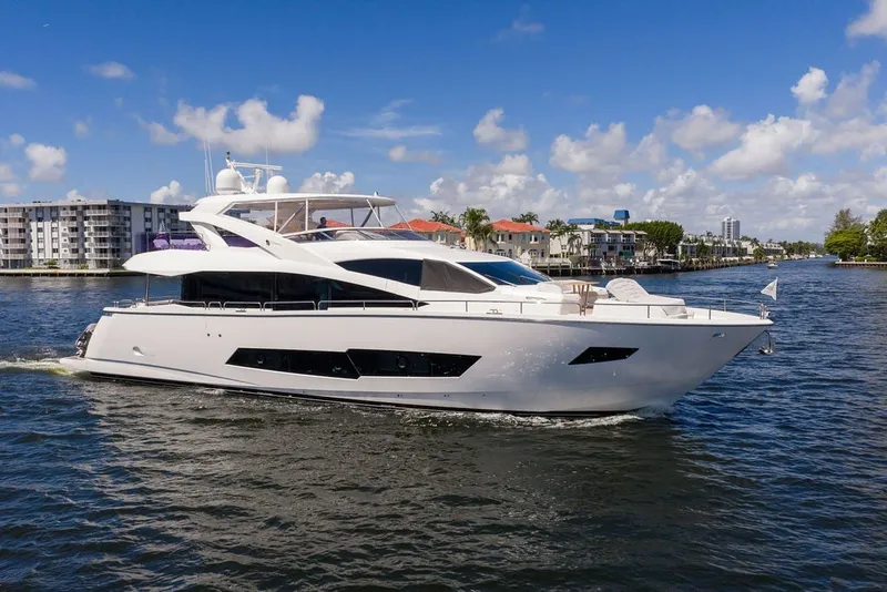 Slide: The Image of 2019 Sunseeker 86 Yacht cruising on a sunny day near waterfront buildings. - 21