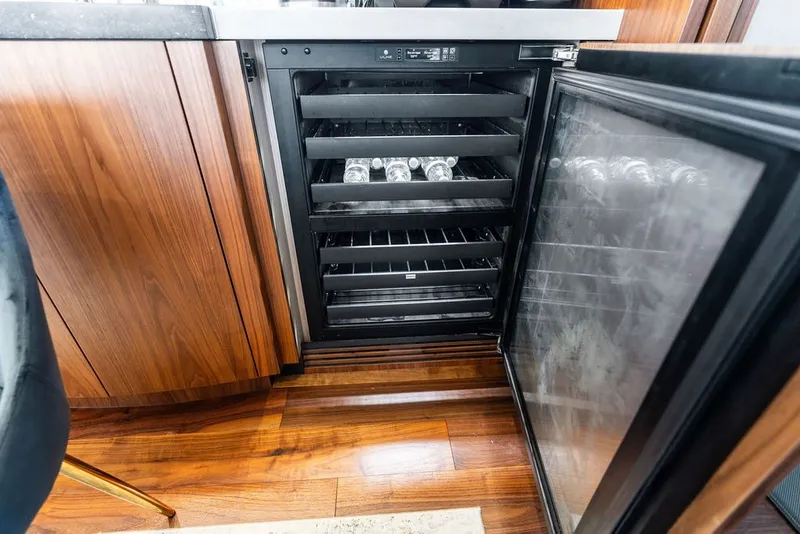 Slide: The Image of Open wine cooler on 2019 Sunseeker 86 Yacht, showcasing sleek wooden cabinetry and modern design. - 108
