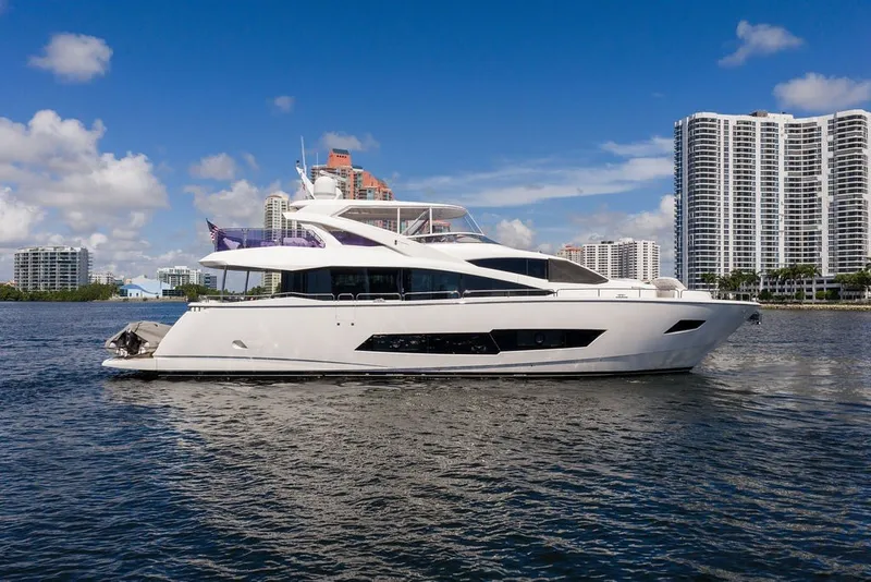 Slide: The Image of 2019 Sunseeker 86 Yacht cruising near city skyline on a sunny day. - 2