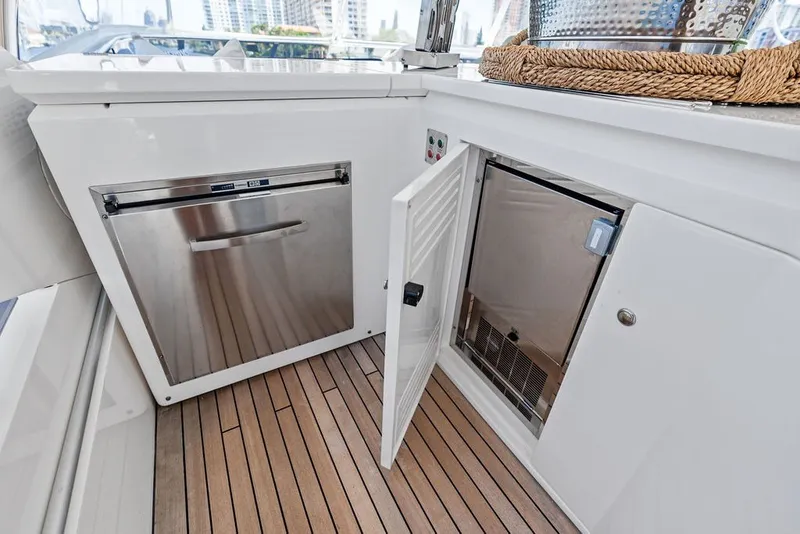 Slide: The Image of Luxurious 2019 Sunseeker 86 Yacht kitchen area with stainless steel appliances and wooden flooring. - 56