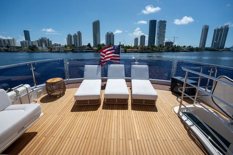 Slide: The Image of Luxurious Sunseeker 86 Yacht deck with sun loungers, city skyline view, 2019 model. - 48