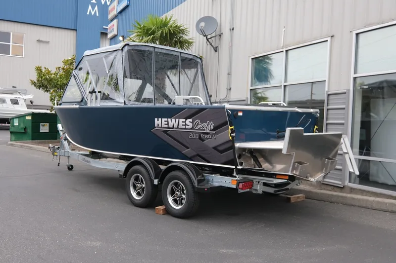 Slide: The Image of 2023 Hewescraft 200 ProV ET boat on trailer outside industrial building. - 4