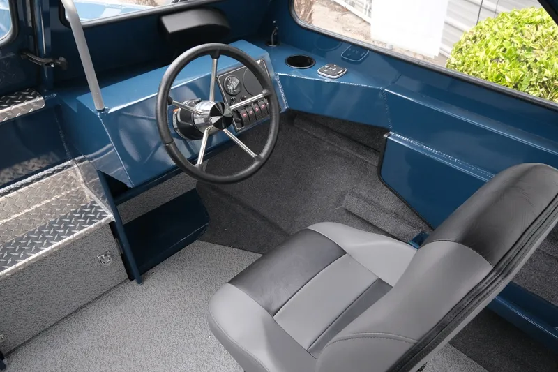 Slide: The Image of Interior of 2023 Hewescraft 200 ProV ET boat, featuring steering wheel and seating. - 11