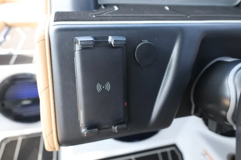 Slide: The Image of Close-up of a boat dashboard with a wireless charger and speaker. - 49