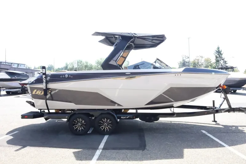 Slide: The Image of The image shows a 2027 Tigé Z3 boat on a trailer in a parking lot. It features a sleek design with a distinctive black roof and stylish lines. - 8