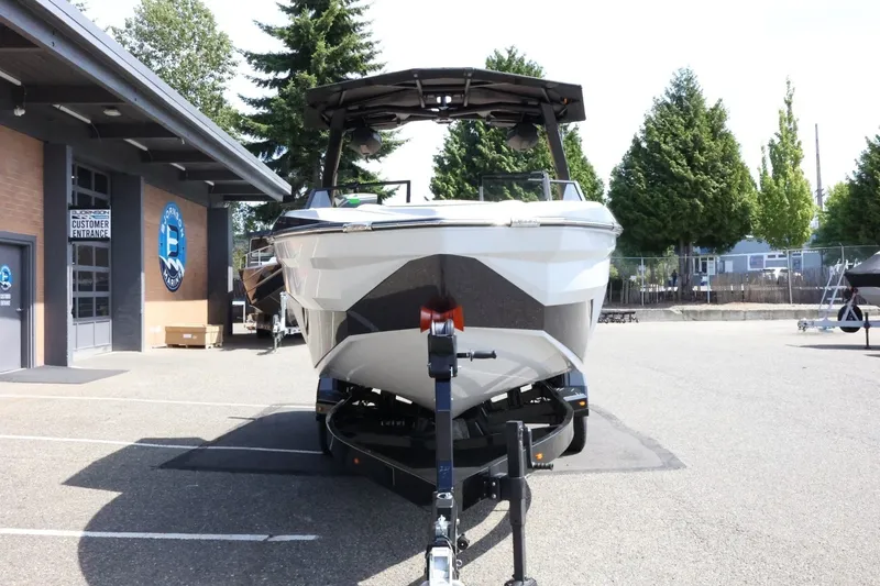 Slide: The Image of A 2027 Tigé Z3 boat on a trailer in a parking lot, surrounded by trees. - 4