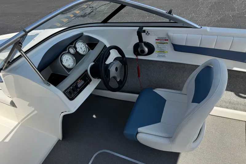 Slide: The Image of 2012 Bayliner 195 Bowrider cockpit with steering wheel, gauges, and blue-white seating. - 23