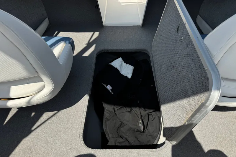Slide: The Image of Storage compartment in a 2012 Bayliner 195 Bowrider boat with clothing inside. - 22