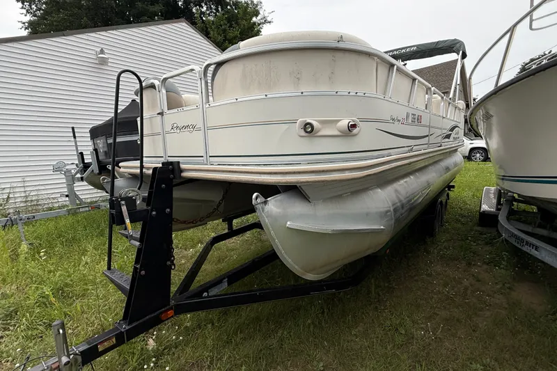 Slide: The Image of 2004 Sun Tracker Party Barge 22 Regency Edition pontoon boat on trailer, parked on grass. - 14