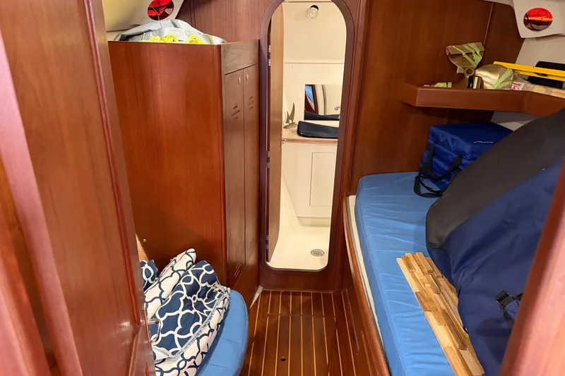 Slide: The Image of Interior of 1994 Hunter Passage 450 sailboat with wooden cabinetry and blue cushions. - 13