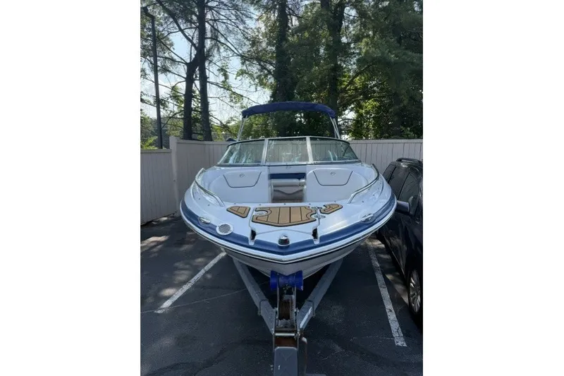 Slide: The Image of 2008 Crownline 200 LS boat parked on a trailer in a wooded area. - 3