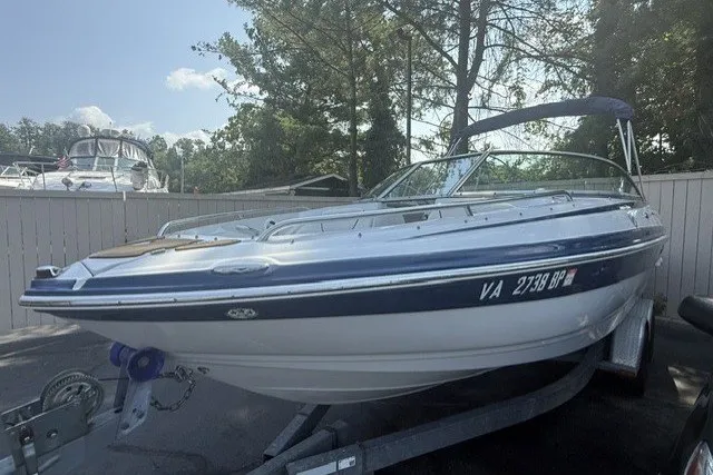Slide: The Image of 2008 Crownline 200 LS boat on trailer, parked outdoors with trees in background. - 1