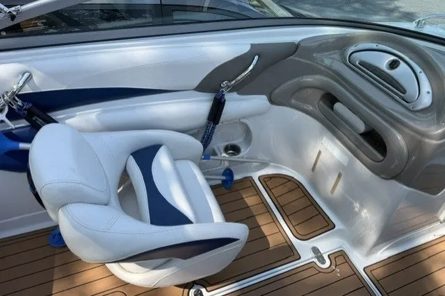 Slide: The Image of 2008 Crownline 200 LS boat interior with white and blue seating, wood-style flooring. - 12