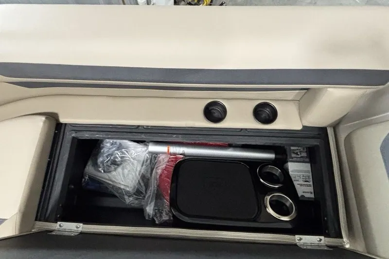 Slide: The Image of Storage compartment in a 2027 Premier 220 Sunscape RL - CL boat, featuring cup holders and accessories. - 7