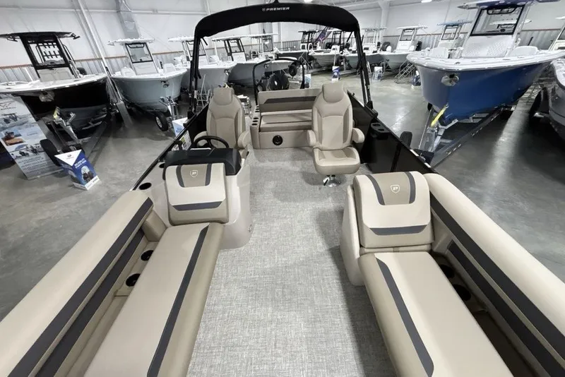 Slide: The Image of 2027 Premier 220 Sunscape RL - CL pontoon boat interior with beige seating in showroom. - 18