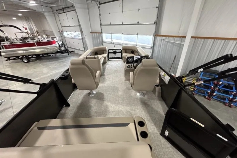 Slide: The Image of 2027 Premier 220 Sunscape RL - CL pontoon boat interior in showroom, featuring beige seating. - 15