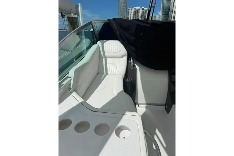 Slide: The Image of 2021 Monterey 355 Sport Yacht interior with white seating and cup holders, city skyline view. - 20