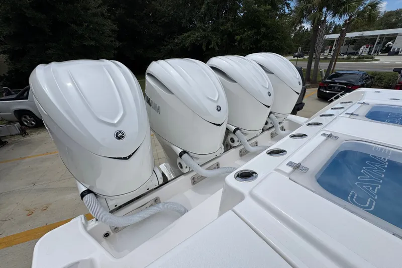 Slide: The Image of Four Yamaha outboard engines on a 2027 Caymas 401 DR boat, parked outdoors. - 56