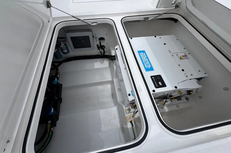 Slide: The Image of 2027 Caymas 401 DR boat storage compartments with electrical components and wiring. - 59