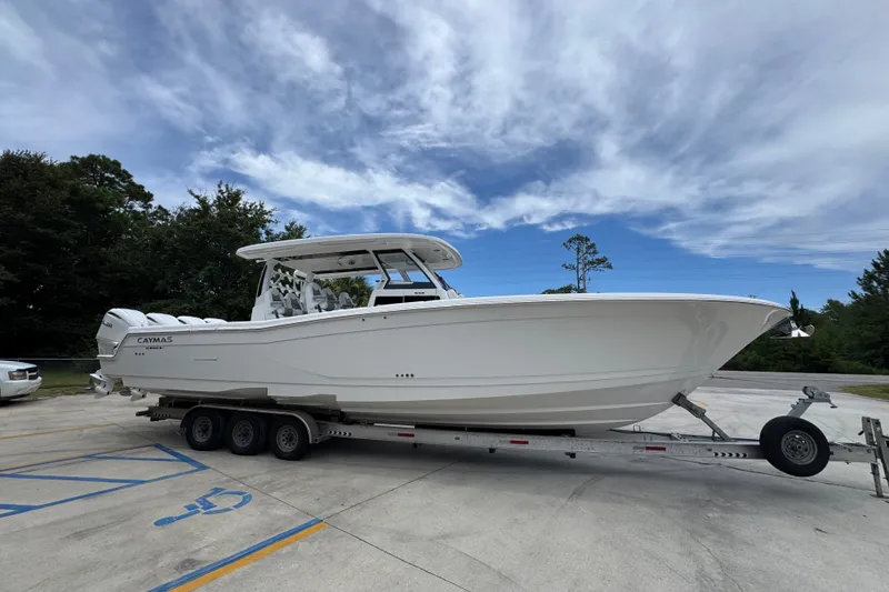 Slide: The Image of 2027 Caymas 401 DR boat on trailer under a cloudy sky. - 11