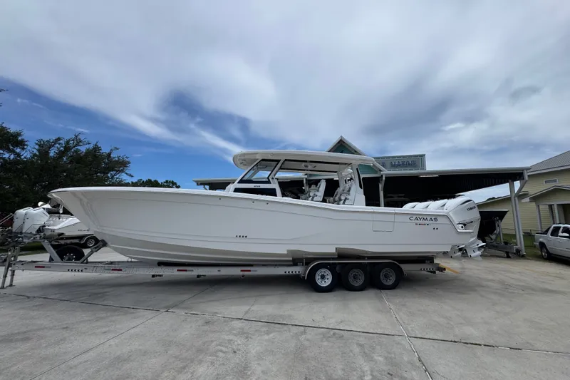 The Image of 2027 Caymas 401 DR boat on trailer, parked outdoors under cloudy sky. - 1