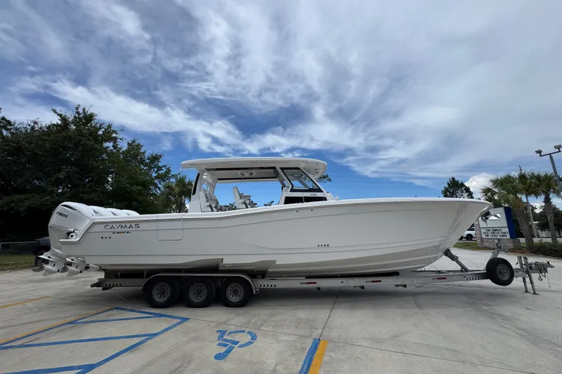 Slide: The Image of 2027 Caymas 401 DR boat on trailer under cloudy sky. - 12