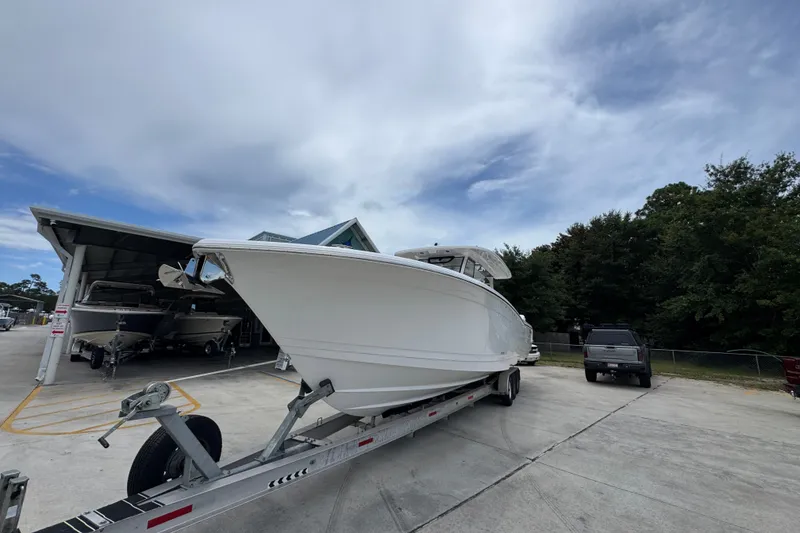 Slide: The Image of 2027 Caymas 401 DR boat on trailer, parked outdoors under cloudy sky. - 5